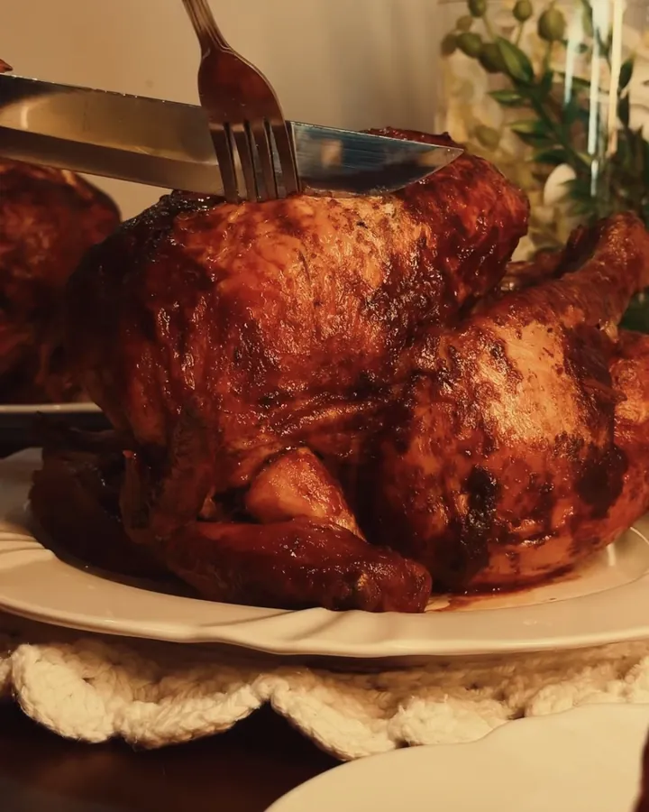 Frango assado inteiro sendo cortado à mesa